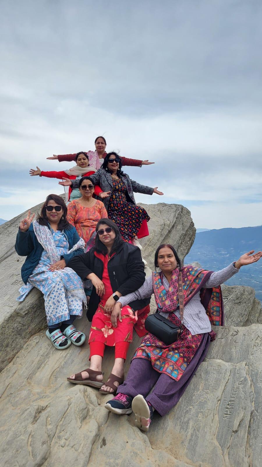 A group celebrating together at a Mukteshwar valley viewpoint