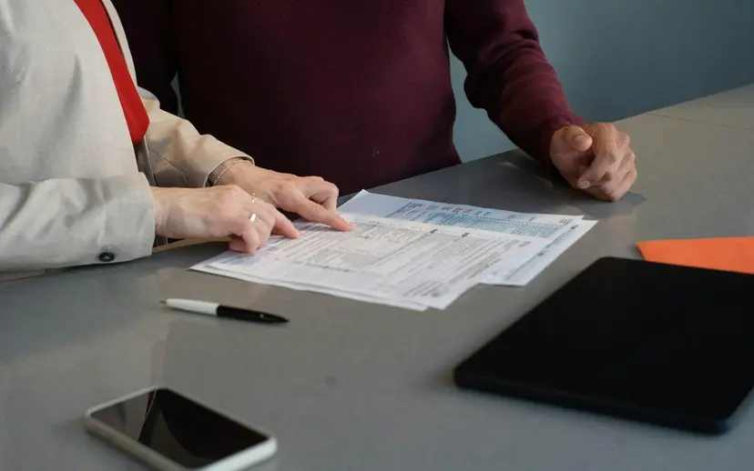 Two people going through a tender document list together