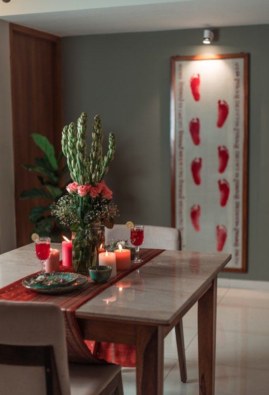 Family-room reference with a timber table, red accents and framed kumkum-print artwork
