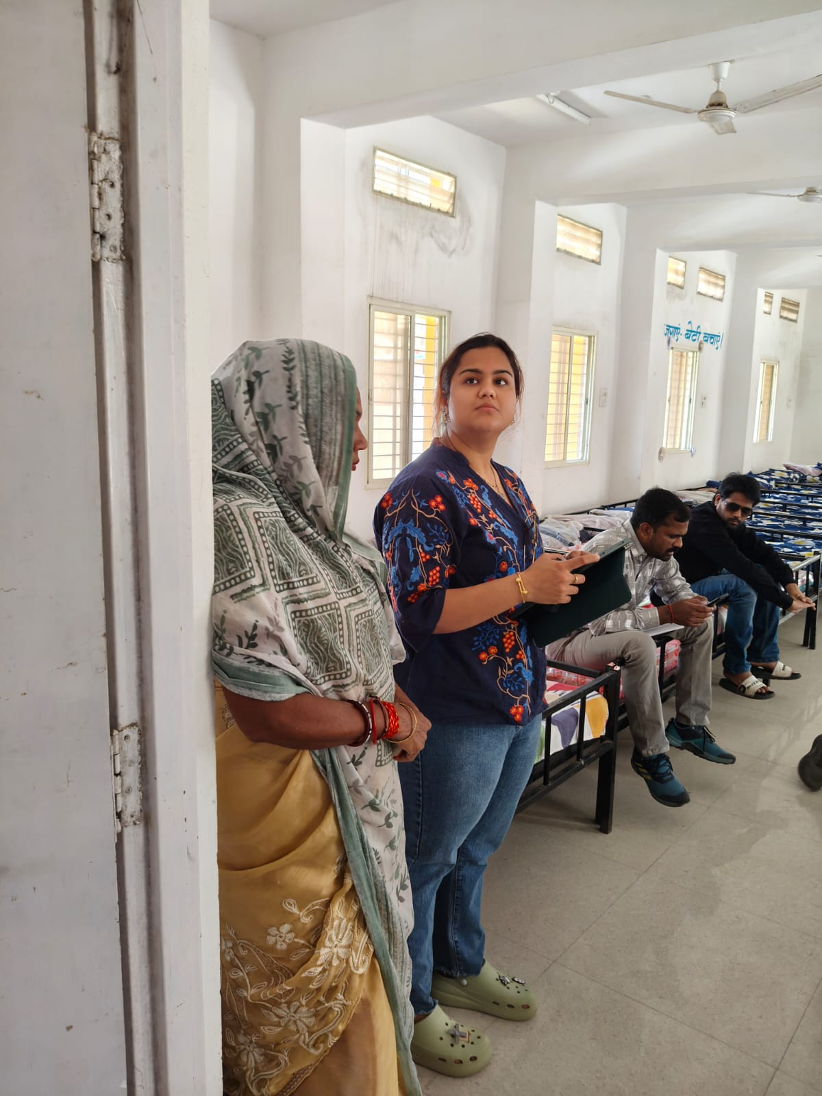 Site walkthrough inside a hostel dormitory with beds and high windows