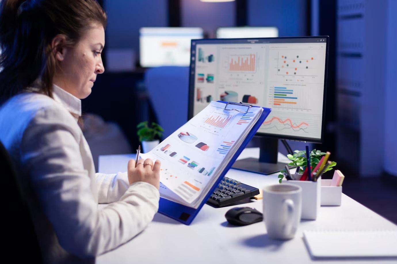 A workplace manager reading occupancy and utilization charts at her desk