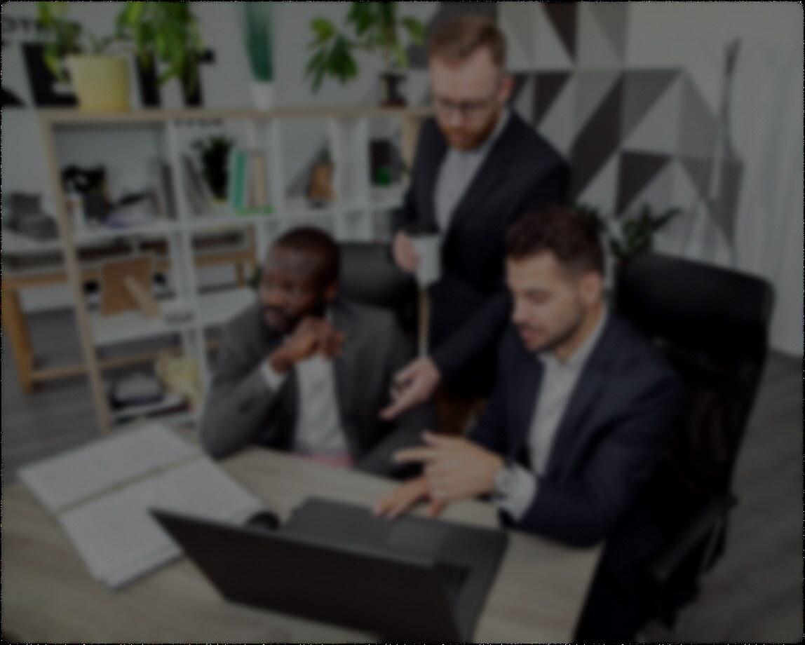 Facility managers reviewing office plans around a laptop