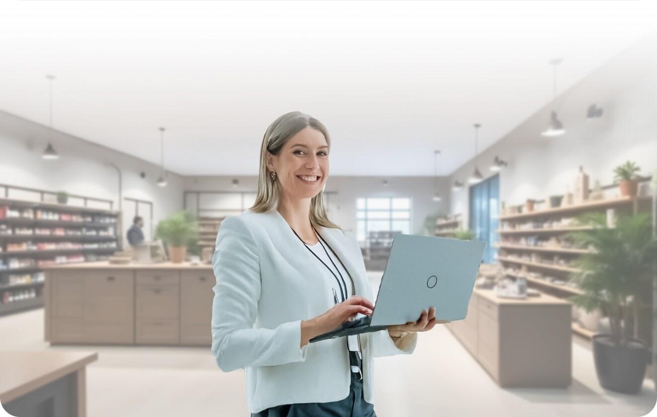 A store manager on the shop floor reviewing workplace data on a laptop