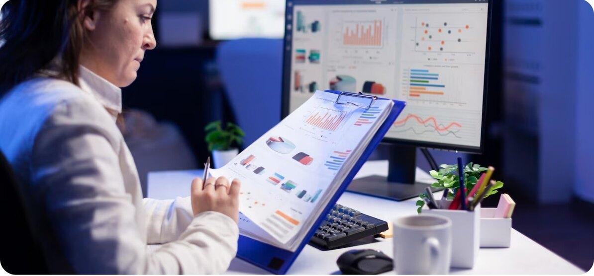 Workplace manager reading occupancy charts on a desktop screen and a tablet