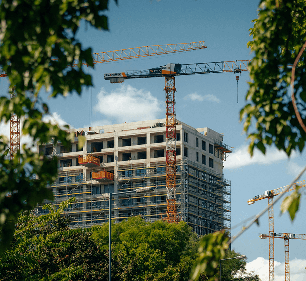 A residential tower under construction against a crane and open sky